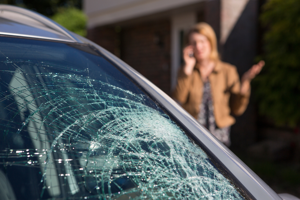 Woman,phoning,for,help,after,car,windshield,has,broken